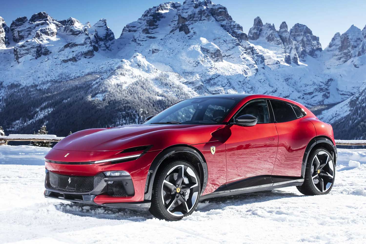 Ferrari Purosangue roja sobre un paisaje nevado en los Alpes italianos combinando elegancia y rendimiento en condiciones invernales